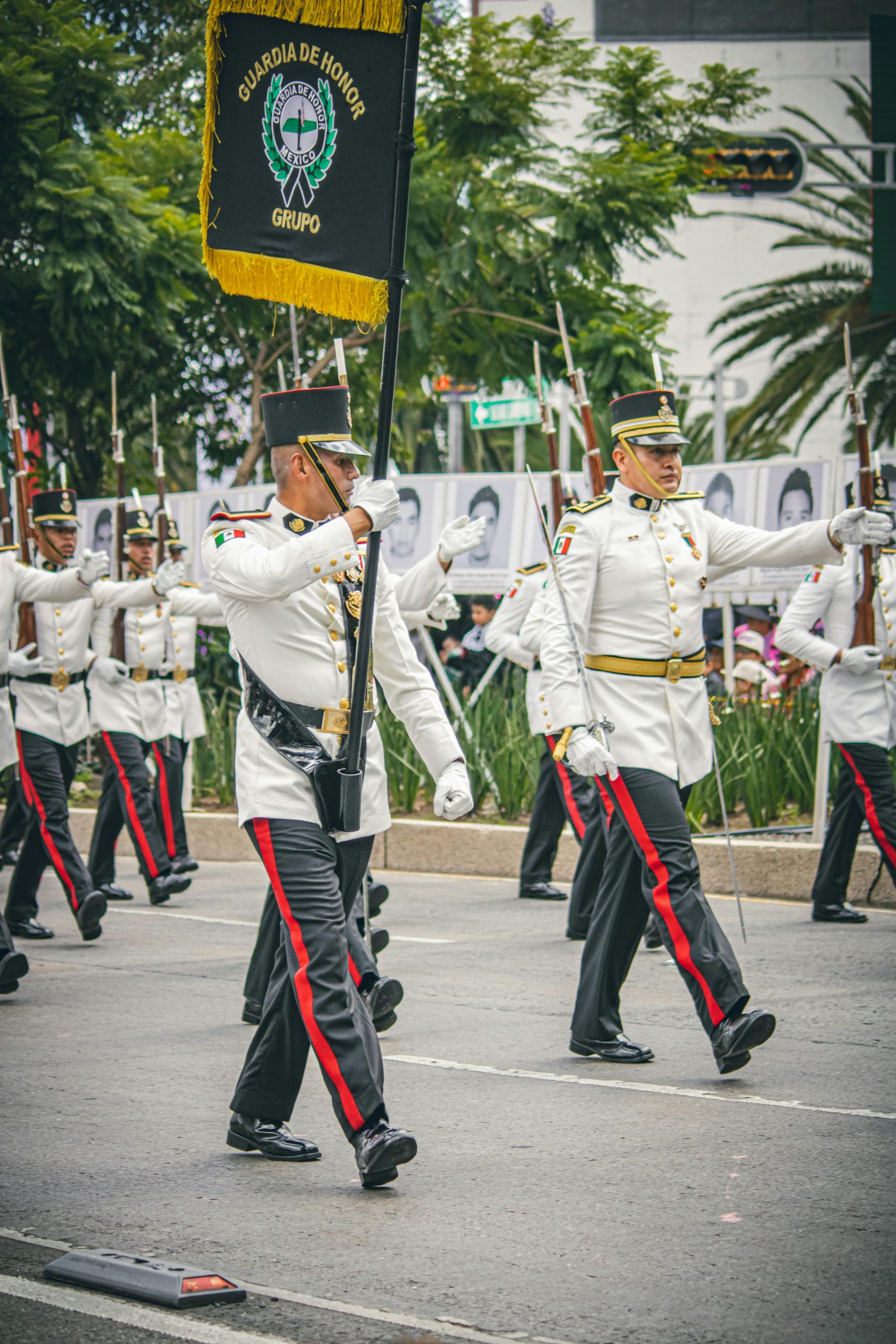 Soldiers in formal uniforms marching in a parade in Mexico City, showcasing military regalia.