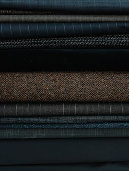 Close-up of stacked textured fabrics in diverse materials and patterns.